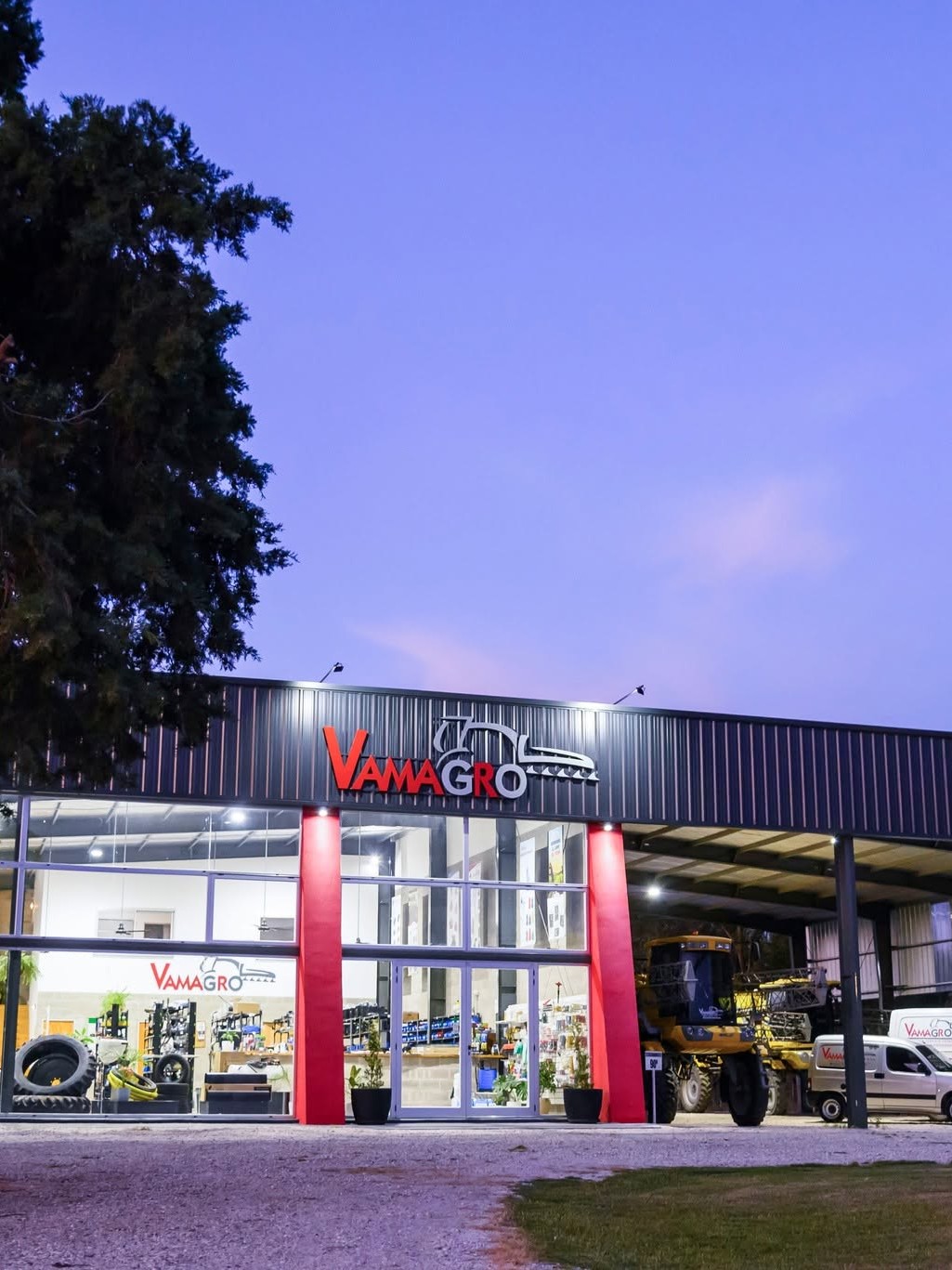 Frente del local de Vamagro en Bell Ville al atardecer, con el cartel iluminado